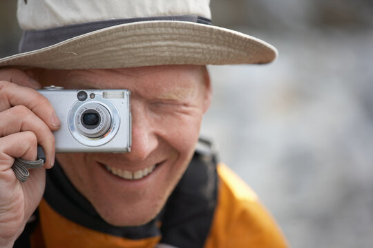man taking picture with digital point and shoot camera in Greenland