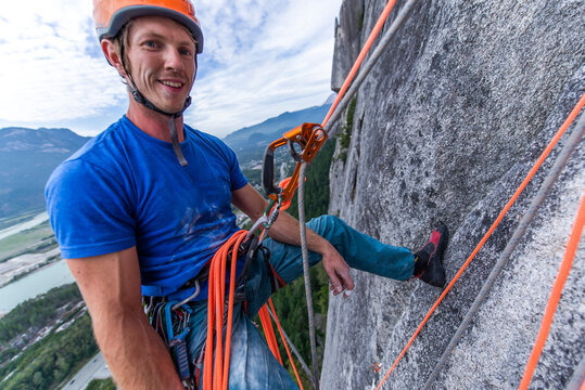 Man Resting While Rock Climbing Hanging On Rope With Ascender