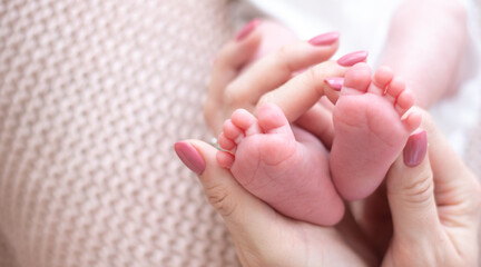 Little feet newborn baby on beige blanket in mom's hands. love and happiness in family. Concept of child problems, feeling safe, parent care. Copy space for text.
