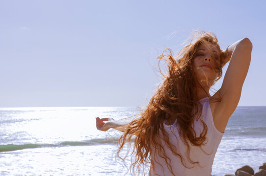 Red haired woman on windy beach