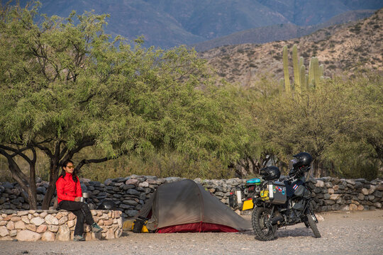 woman sitting beside motorbike camp at the Ruinas de Quilmes