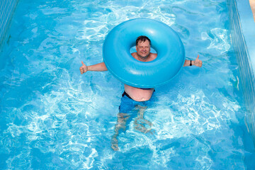 Male tourist with an inflatable ring in the pool, close-up.