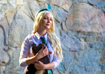 Fashion shoot a beautiful young sexy girl stands against a stone wall with a beautiful texture