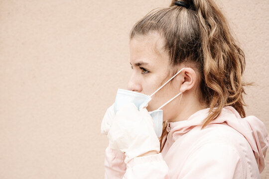 one blonde girl wearing latex gloves and face masks is showing the way she protects herself from coronavirus, bacterias, virus, fungus, etc. She removed mask to take clear breath. 