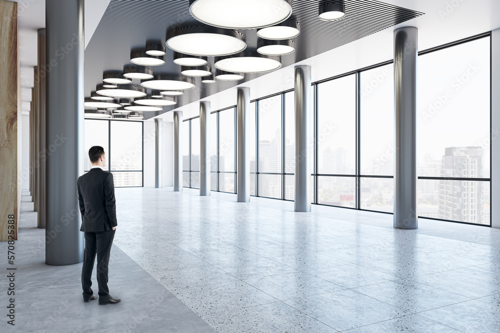 Poster man in black suit looking on city skyscrapers on background from business center high floor stylish 