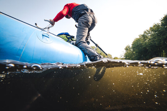 Man climbing out of water onto drift boat