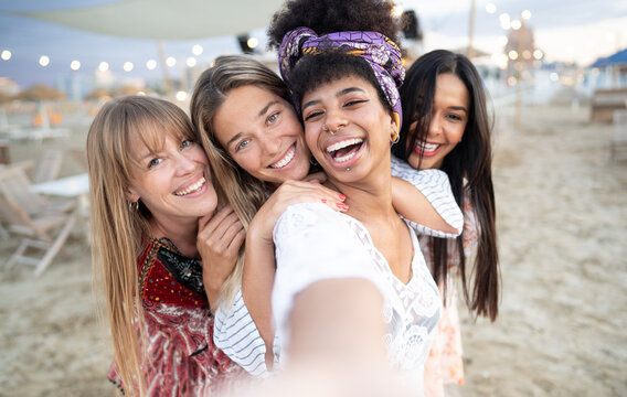 Group of girls taking selfie picture smiling at camera - Young girls celebrating standing outside and having fun at beach party