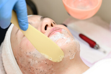 The process of applying a moisturizing mask to the face in a spa salon.