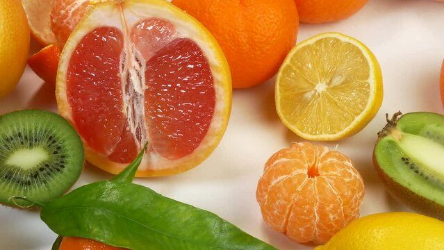 Many fresh fruits lie on the table. Beautiful lemons and tangerines for healthy eating. Citruses lie beautifully on a white table.