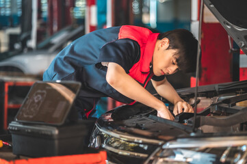 Auto service, repair, maintenance concept. Mechanic checks the car at the service station.Vehicle service maintenance asian men checking  car  in garage.