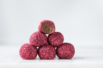Raspberry coconut and chocolate truffles, homemade chocolate bonbons on white background