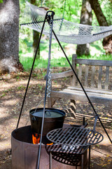 Tripod with dutch oven hanging over open fire