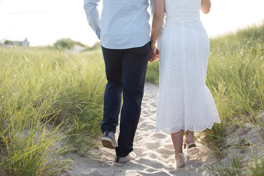 Romantic Couple From Behind Walking At Beach Hand In Hand