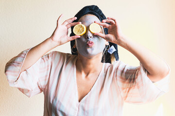 Happy girl applying a facial cleansing mask while