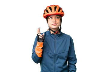 Young cyclist girl over isolated chroma key background with fingers crossing and wishing the best