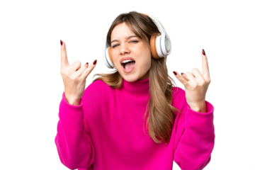 Young girl over isolated chroma key background listening music making rock gesture