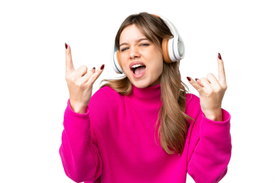 Young girl over isolated chroma key background listening music making rock gesture