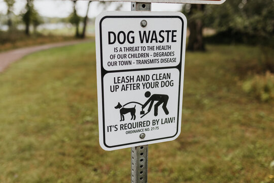 Close up image of dog waste sign along local walking trail