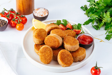 chicken nuggets in a plate on a light background, tomato sauce, 