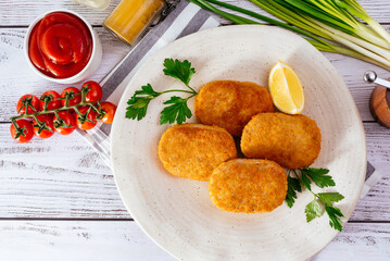 chicken cutlets in a plate on a light wooden background