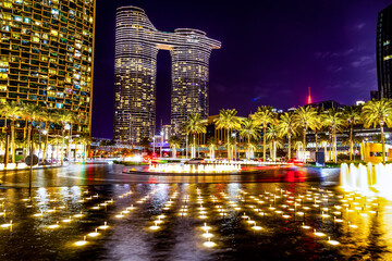 City center sidewalks in night light. Palm trees decorated with shining garlands. Empty city streets.