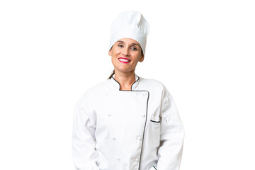 Middle-aged chef woman over isolated background laughing