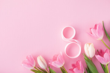 Spring composition with bouquet of pink tulip flowers and 8 number from ribbon top view. Greeting card for International Women Day. Flat lay.