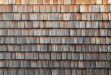 a house wall covered with small wooden tiles,brown background for design