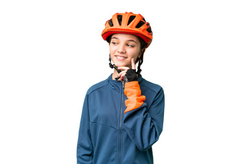 Teenager cyclist girl over isolated chroma key background thinking an idea while looking up - obrazy, fototapety, plakaty
