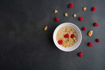 Healthy breakfast. Fresh granola, muesli with yogurt and raspberry on dark background. Top view.