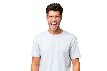 Young caucasian handsome man over isolated background shouting to the front with mouth wide open
