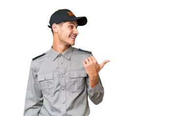 Young security man over isolated background pointing to the side to present a product