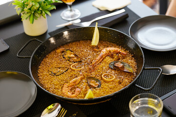 Paella with seafood for two persons in a restaurant on the table.