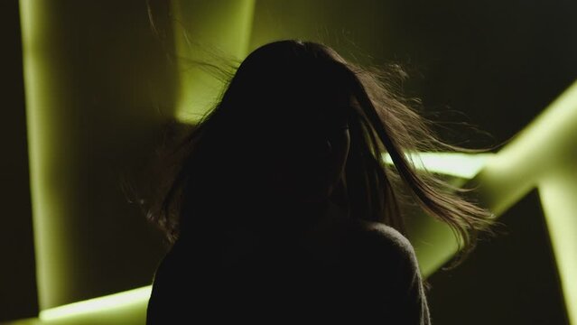 Close up portrait of pretty brunette female model . Beautiful attractive face of young woman . Hair flowing or blowing in wind . Face Changes Depending on the Lighting . Shadow and light movement . 