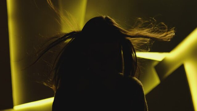 Close up portrait of pretty brunette female model . Beautiful attractive face of young woman . Hair flowing or blowing in wind . Face Changes Depending on the Lighting . Shadow and light movement . 
