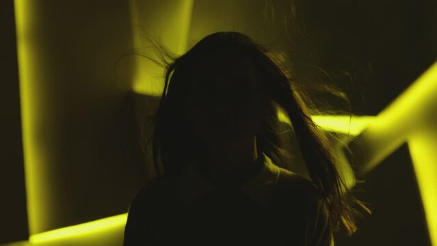 Close up portrait of pretty brunette female model . Beautiful attractive face of young woman . Hair flowing or blowing in wind . Face Changes Depending on the Lighting . Shadow and light movement . 