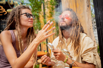 Hippie style couple smoking cigarettes with medical marijuana