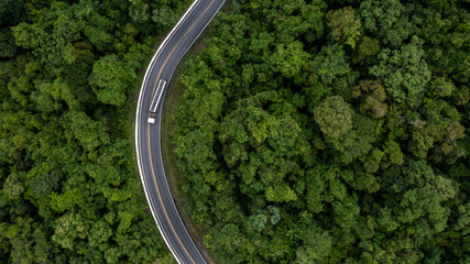 Aerial top view commercial gasoline fuel truck driving through the middle green forest, Gasoline...