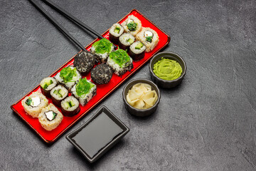 Different types of sushi on a red plate.