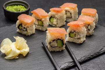 Sushi with cucumber and salmon, chopsticks.