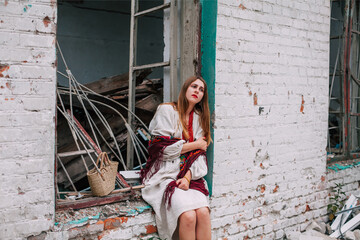 Art work on the theme of the war in Ukraine. A frustrated Ukrainian woman in national dress sits in...