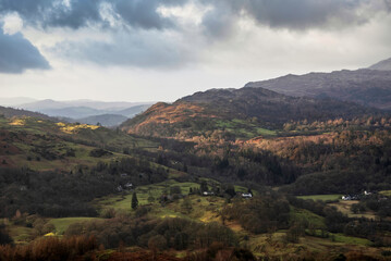 Fototapeta na wymiar Stunning colorful Winter sunrise golden hour landscape view from Loughrigg Fell across the countryside in the Lake District