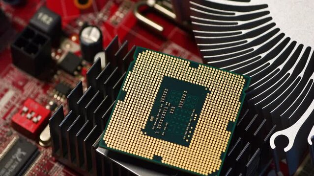 detail of a modern computer processor on top of aluminum heat sinks of a computer red motherboard. tech backgrounds, electronics and engineering