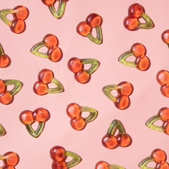 Cherry fruit gummy candy, creative pattern, pastel pink background. 