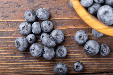 Fresh blueberry in wooden bowl. Concept of healthy and dieting eating.