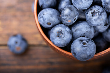 Freshly picked blueberries in  bowl. Bilberry on wooden Background. Blueberry antioxidant. Concept for healthy eating and nutrition