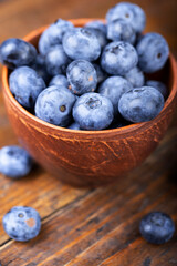 Freshly picked blueberries in  bowl. Bilberry on wooden Background. Blueberry antioxidant. Concept for healthy eating and nutrition