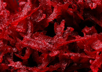 Background and texture of raw fresh juicy grated red beets, close-up,