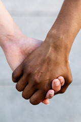 Diversity and support concept with close up shot of two diverse women holding hand
