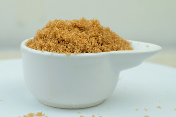 Brown sugar from natural cane juice on a unique white bowl
